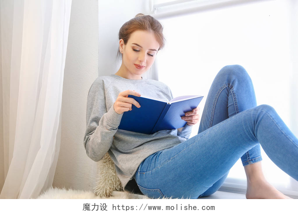 年轻女子靠近窗户读书美丽的年轻女子读书靠近窗口
